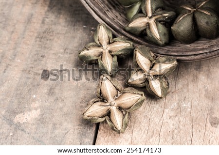 dried capsule seeds fruit of sacha-Inchi peanut with basket on wooden table