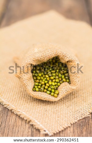 green beans in sack bags with sack cloth on old wooden background