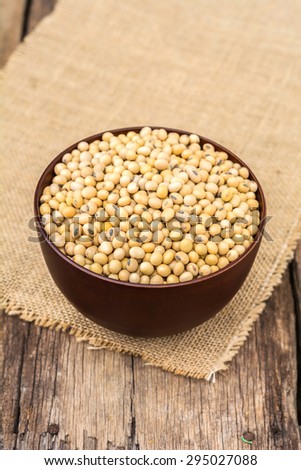 soybean in dish with sack cloth on old wooden background
