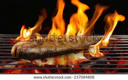Grilled fish with flames on the grill