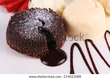 Ice cream, banana, strawberry, chocolate cake with chocolate sauce on white plate