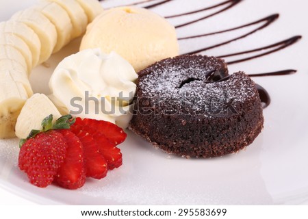 ice cream, banana, strawberry, chocolate cake with chocolate sauce on white plate
