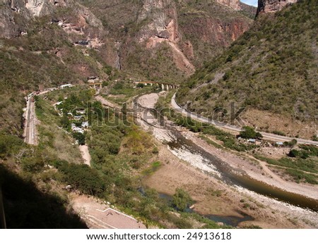 Copper Canyon railway winds its way into the interior of Mexico over a curving bridge  seen here from the third of three levels of train track