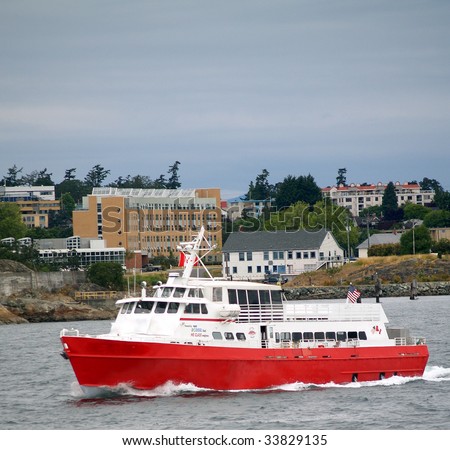 A bio-diesel powered water taxi / small ferry leaves Victoria on Vancouver Island, BC on its way to a Washington state port.  Canadian Forces Base Esquimalt can be seen in the background