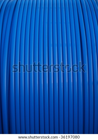 Blue conduit pipe on a large spool