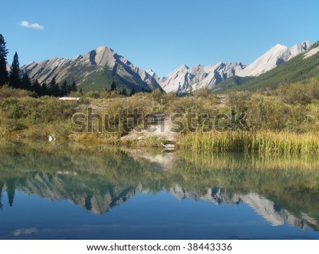 Rocky Mountains reflected in one of the ponds at the \