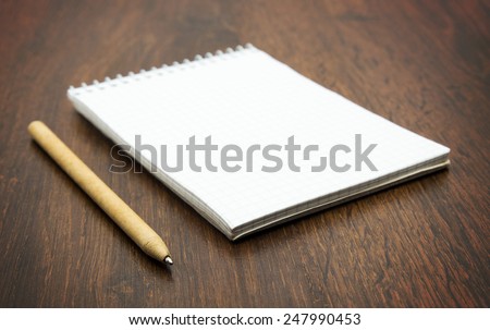 spiral notebook and pen on wooden desk
