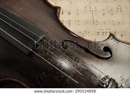 Old violin lying on the sheet of music, music concept