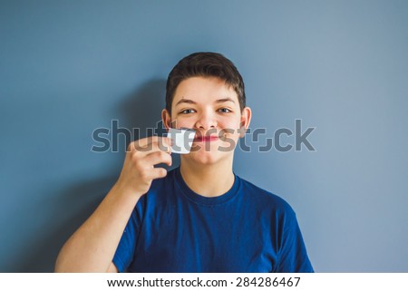 boy tears off an adhesive tape from a mouth. Freedom of speech concept