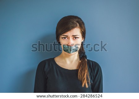 Worried girl with duct tape over her mouth