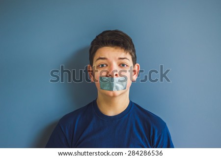 Worried boy with duct tape over his mouth