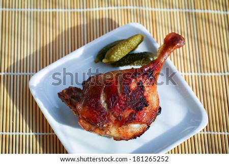 Hot and delicious roast duck leg on a bamboo mat
