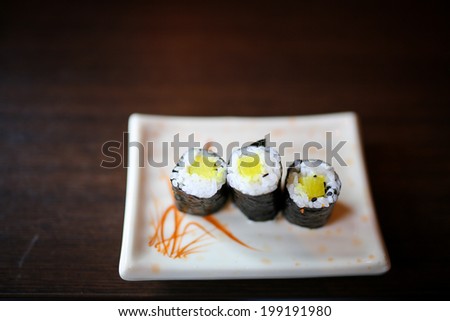 Japanese foods include sushi, nigiri, sashimi, served on small plate on a wooden background