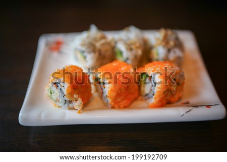 Japanese foods include sushi, nigiri, sashimi, served on small plate on a wooden background