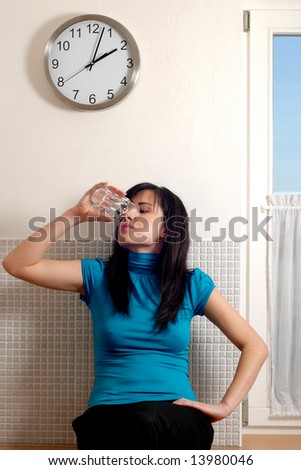A pretty young woman lifting a glass of water