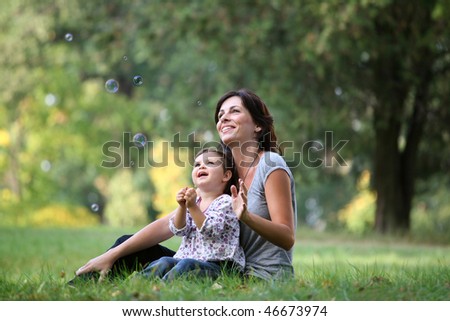 mother and daughter playing with bubble