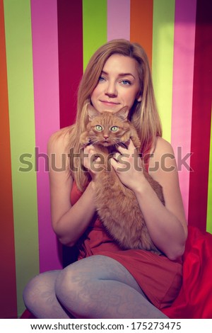 Young beautiful woman with cat on a bright background