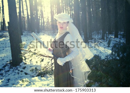 Mysterious woman in a dress with a bat in the woods