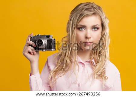 Head shot of a pretty pin-up girl holding a vintage camera.