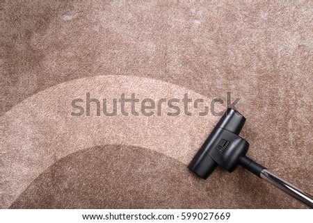Vacuuming carpet with vacuum cleaner. Housework service. Close up of the head of a sweeper cleaning device.