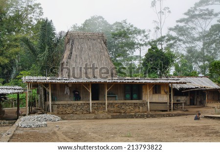 FLORES, INDONESIA - September 22: indigenous traditional thatched house with people at the entrance in the village of Wogo on September 22, 2009 in Flores Indonesia.