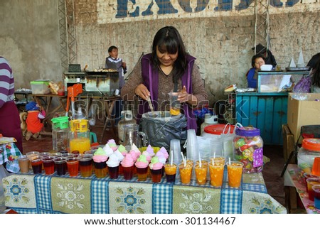 TILCARA ARGENTINA - APRIL 6: Indigenous woman in a market stall selling and preparing fruit juices on April 6, 2015 in Tilcara, Jujuy province, Argentina
