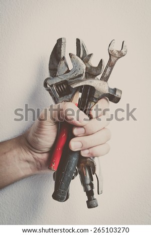 Hand of male holding old tools renovation on white background, vintage color