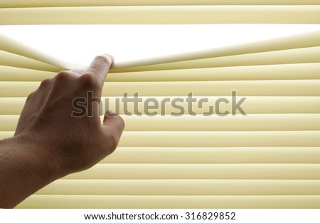 Closeup of hand opening venetian blinds. Place for text