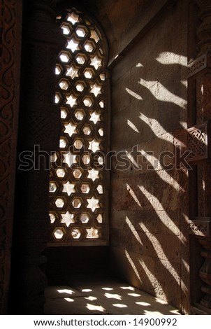 The sun shining through the ornately carved stone window inside the Alai Darwaza, built in 1311 as the southern entrance to the Qutab Minar, one of the largest standing stone minarets in the world.