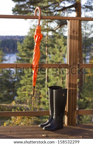 Orange umbrella and rubber boots