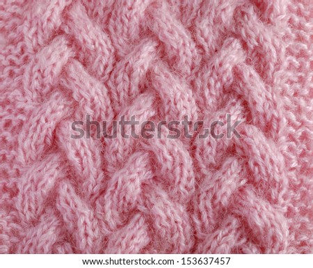 Pink jersey is made by hand. It is decorated with raised pattern and photographed closely.