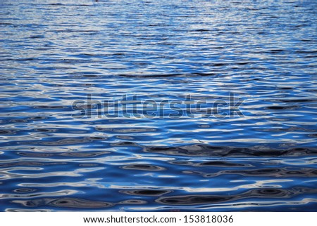 Quiet blue water with waving surface is photographed with diminishing perspective.