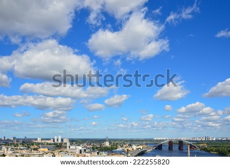 Light clouds are flying on the blue sky above the oldest district Podol with a river port in the right riverbank of Kiev.
