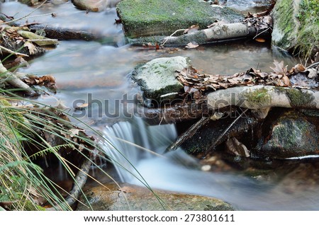 A small brook is running over pebbles in the mountain slope. It is photographed at long shutter speed.