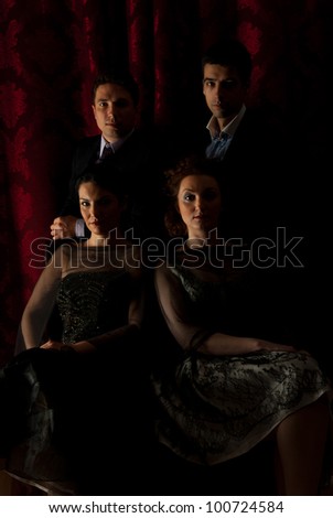 Elegant  four friends people posing in darkness