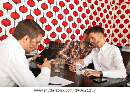 Man telling a secret to other man in a business meeting