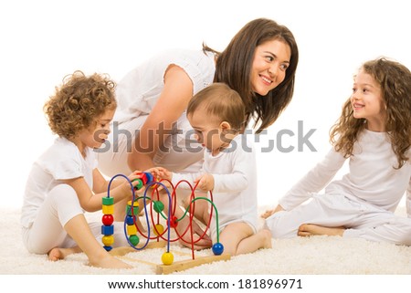 Happy family home,two kids playing with a wooden toy in front of image and mother having fun and conversation with one of daughter