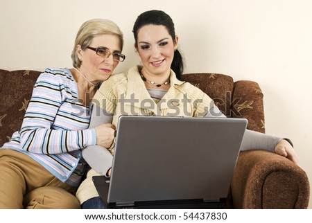 Mother and daughter using laptop home
