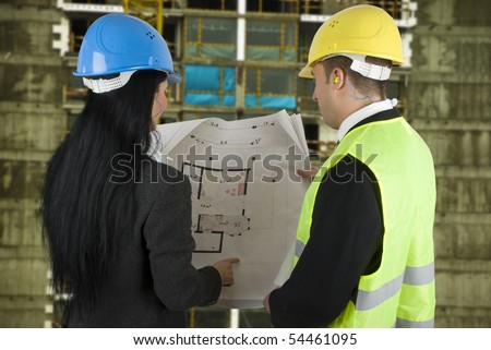 Engineer on the site showing to the buyer what the project, both with protective helmet