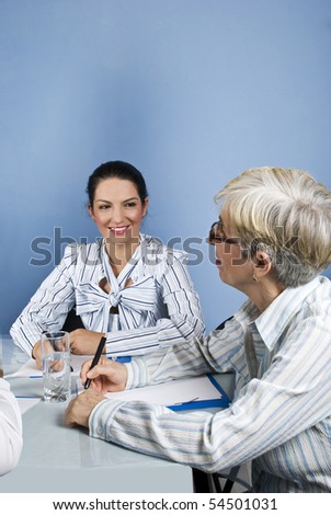 Two businesswomen having an conversation at business meeting,the senior businesswoman looking up
