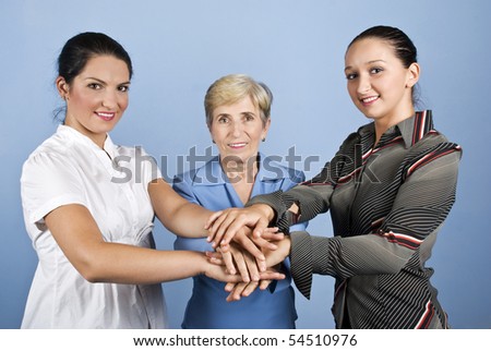 United three  business women, young and senior with their hands together in front of image, concept of successful team