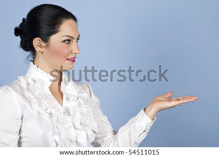 Beautiful woman with head in profile smiling and make a presentation with hand to copy space
