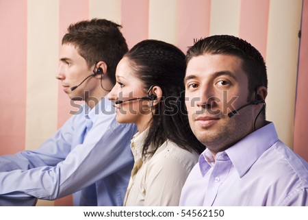 Two business men and one businesswoman  customer service working in office,focus on first man that looking at ypo