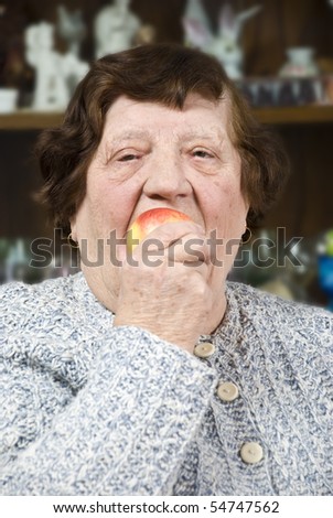 Elderly woman eating an apple concept of healthy lifestyle