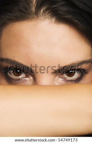 Portrait of beautiful woman  who cover her face with hand and let to see only  eyes with make up