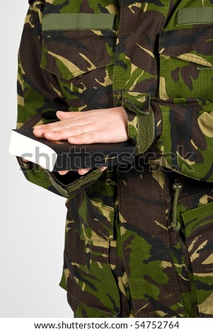 Soldier in the army swear with hand on bible to defend the country isolated on white background