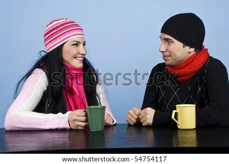 Young couple having a funny conversation and standing  face to face at table enjoying a cup of tea together