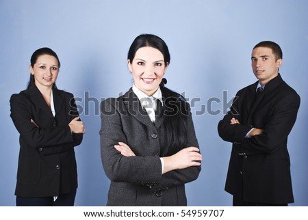 Beautiful young business woman leader  standing with arms folded in front of image in the middle of two colleagues