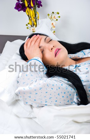 Woman having a bad headache suffering and holding a hand on her forehead