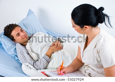 Man patient lying on bed in hospital and having an conversation with his doctor woman